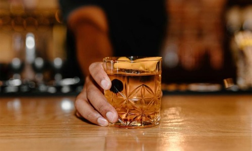 a hand holding holding a cocktail glass
